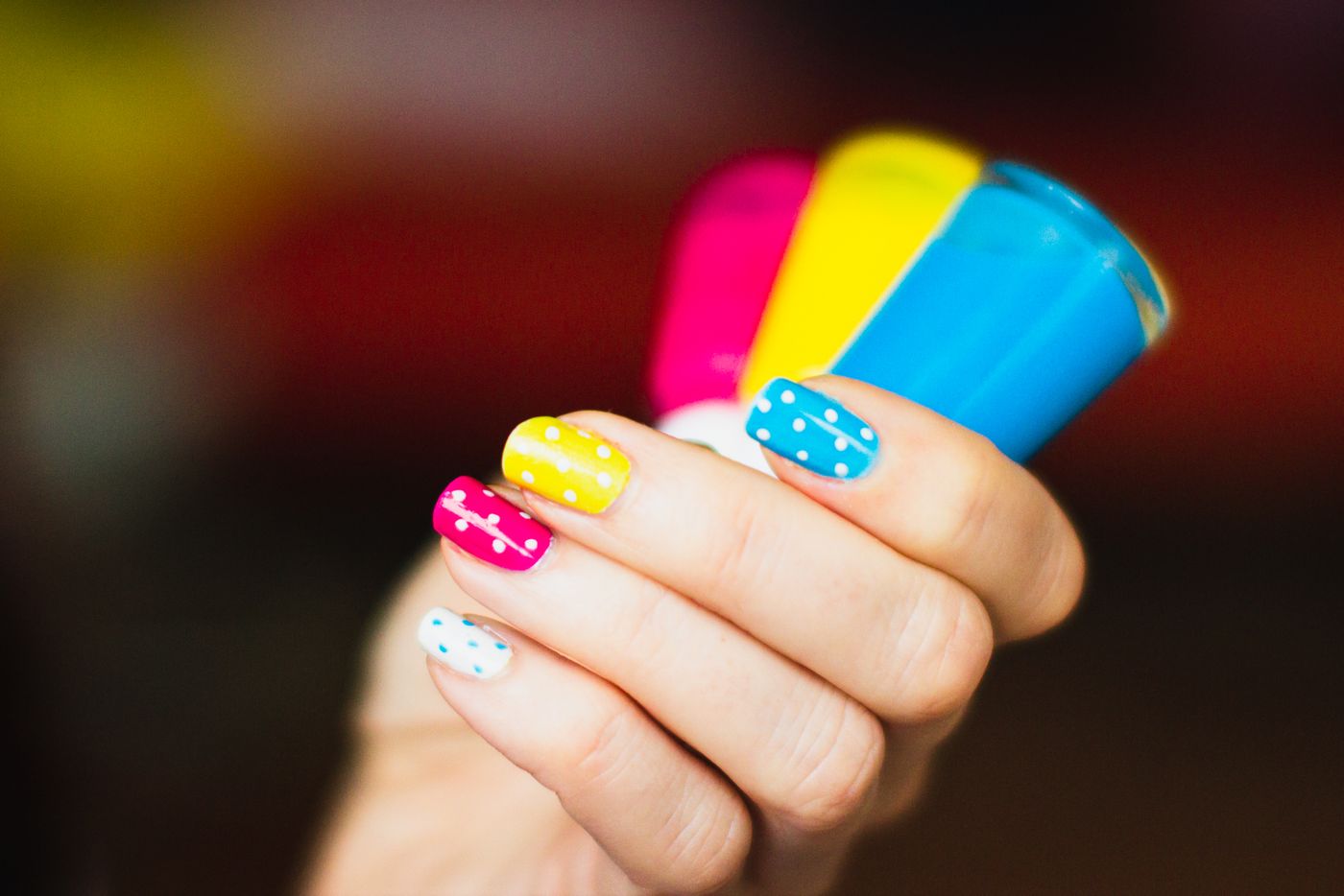 Colorful polka dot nail art with polish bottles
